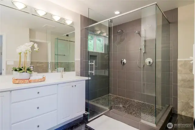 The spa-like en suite bathroom features a large, double shower designed for relaxation and rejuvenation. The generous walk-in closet provides ample storage and organization, making daily routines effortless.