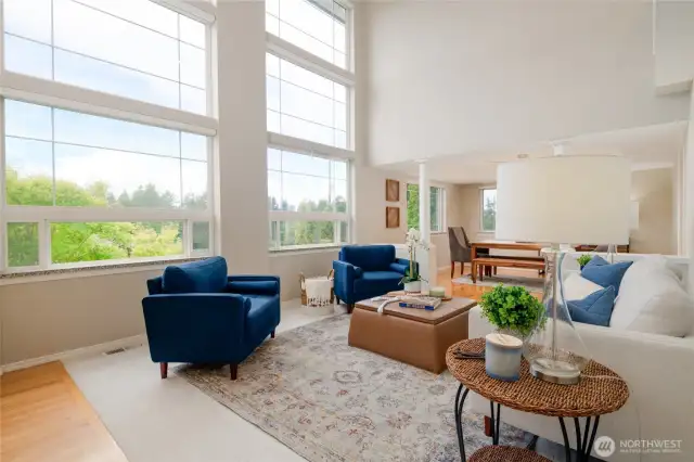 Soaring 20-foot ceilings and dramatic floor-to-ceiling windows flood the open-concept living room with natural light, bringing the outdoors in.