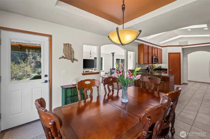The dining area features a tray ceiling and a door out to a covered portion of the patio for your outdoor kitchen or BBQ for year-round enjoyment.