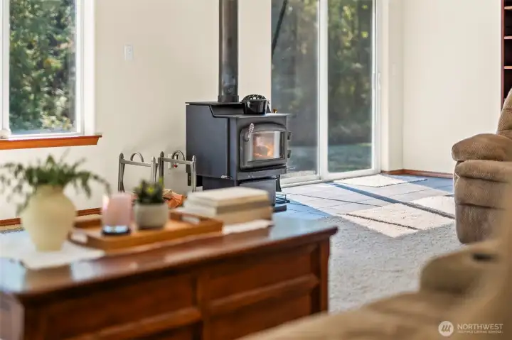 There's nothing a like a woodstove on those cold winter nights! Some say nothing warms you throughout quite like a wood stove. There is a sliding glass door here that leads out to the large back patio and hot tub.