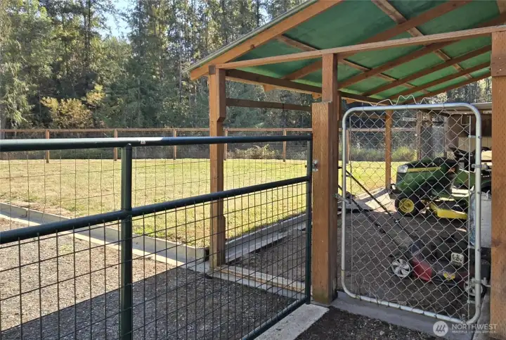 Dog run, covered storage, mower/tractor parking, etc. There is a drive through gate here for access to the fenced back yard from the carport and driveway area.