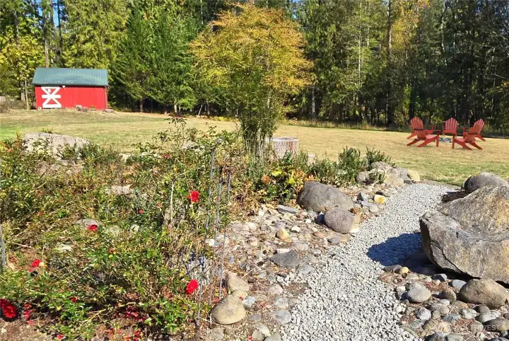 Beautifully landscaped, with a firepit too! There are currently no chairs around the firepit. These were virtually added, but the firepit is there.
