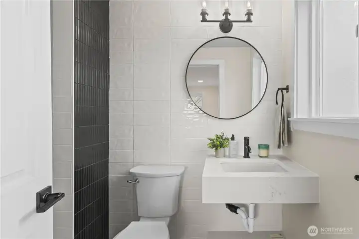 Sink, commode and entry to shower off the primary!  Adorned with tile work and custom trim.