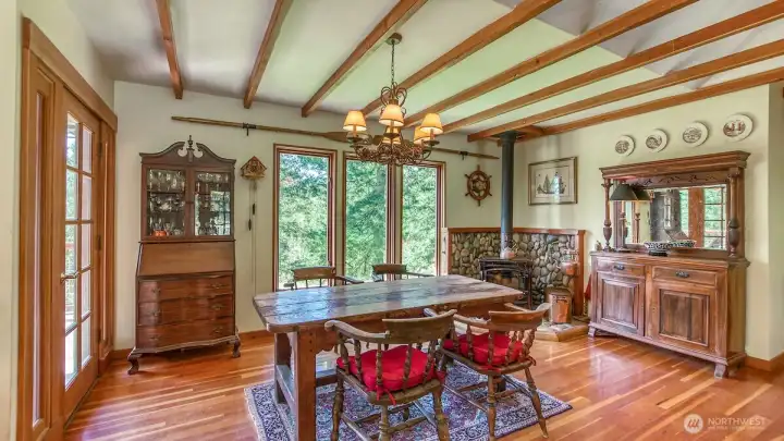 The dining room with garden views, access to a deck and a cozy wood burning fireplace.