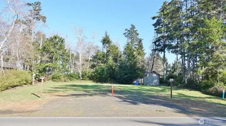 Front view of this great camping/building lot with a huge/wide driveway/culvert, water, sewer, power, shed.