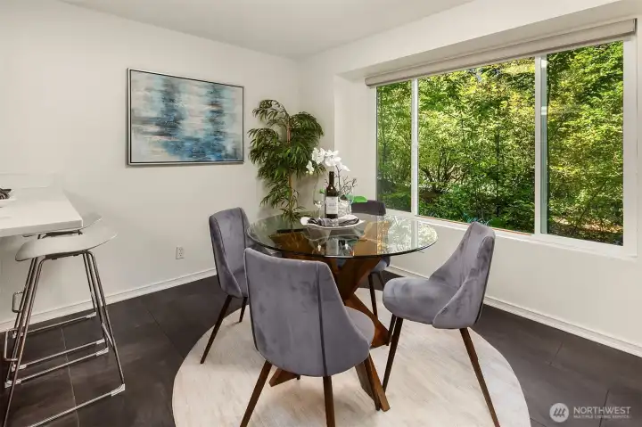 Dining area framed by large windows and additional barstool seating.
