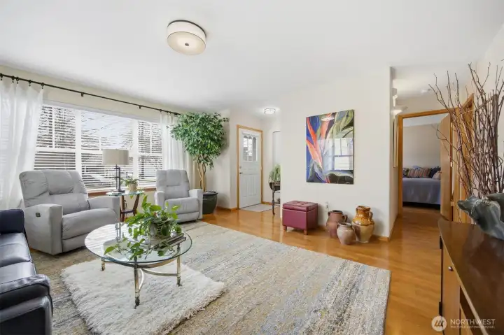 Looking across the living room with the defined front entry and the second bedroom down the hall by the 3/4 bath.