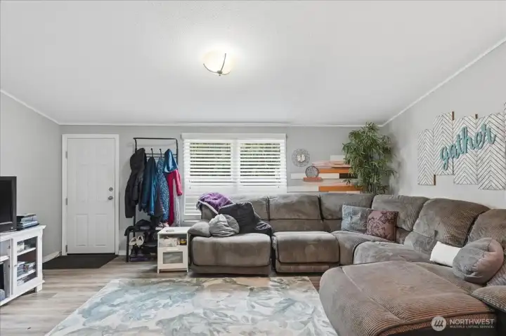 Living room with vaulted ceilings looking towards the front door.