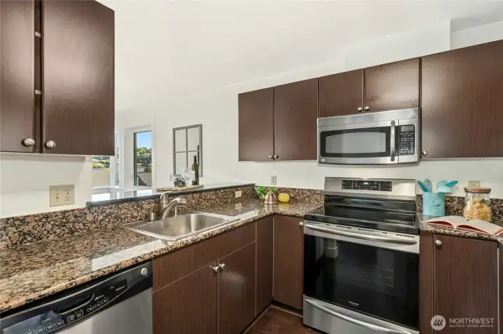 The kitchen makes daily living easy, with bar seating, granite counters, stainless appliances, and great storage.