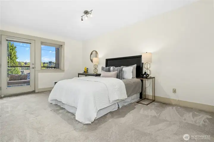 The primary suite easily fits a king-sized bed (not shown--that is a queen-sized bed in the photo) and access to the covered deck.