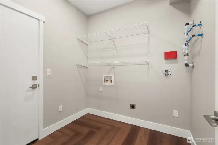 Laundry area with storage racks. Door to the left goes into the garage. You'll love the ease of bringing groceries straight into the kitchen! Laundry area with storage racks. Door to the left goes into the garage. You'll love the ease of bringing groceries straight into the kitchen!