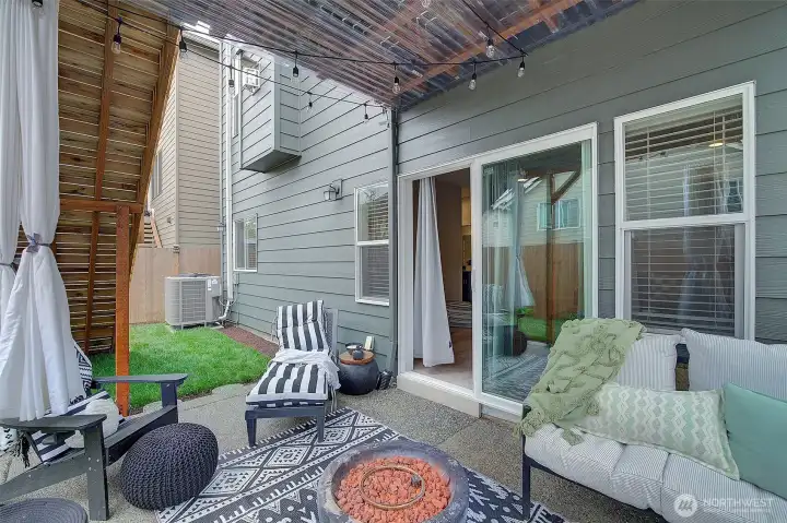 A covered outdoor retreat extends the living space into the fenced backyard.