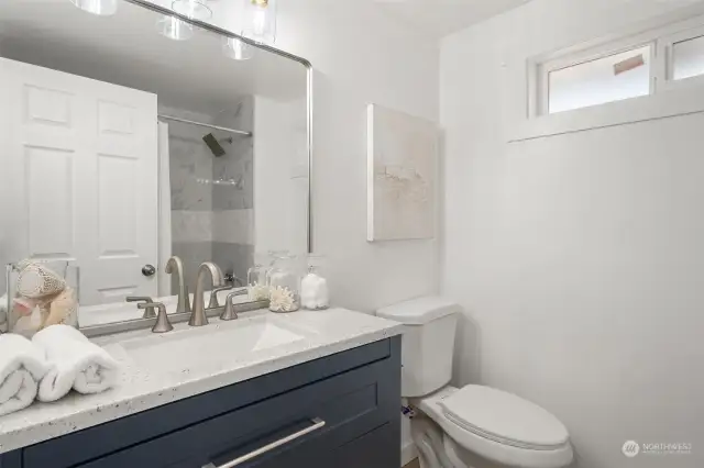 Freshly remodeled full bathroom with matching vanity.