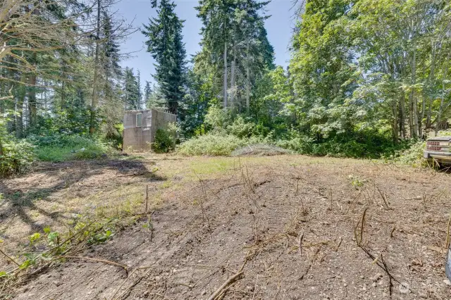 Flat area just above west side driveway.