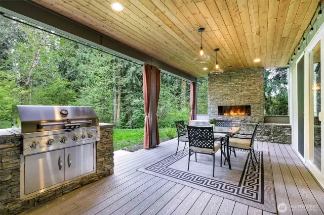 Covered deck off main level living area features  built-in barbecue and gas fireplace.