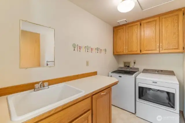 Nice large laudry room with sink and cabinets.
