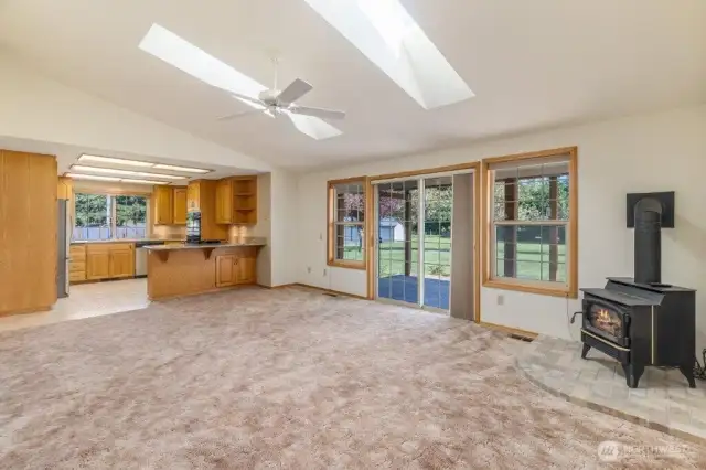 Skylights and a gas stove highlight the truly large living room, open to the kitchen and with a slider to the covered back deck.