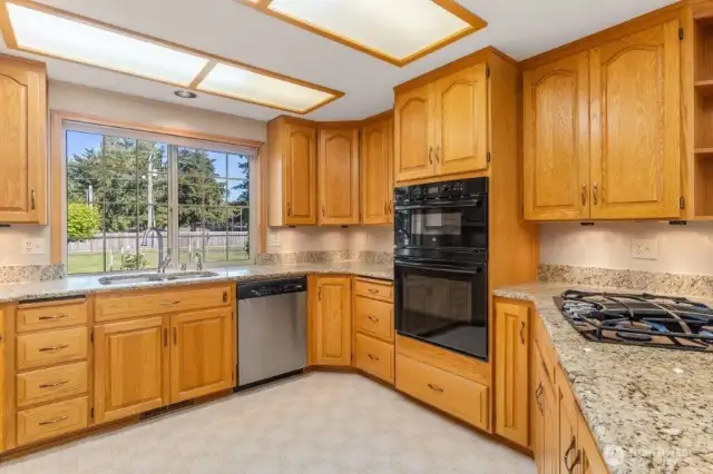 Updated kitchen features granite counters, gas cooktop, a dual wall oven/microwave, and lots of cabinets.