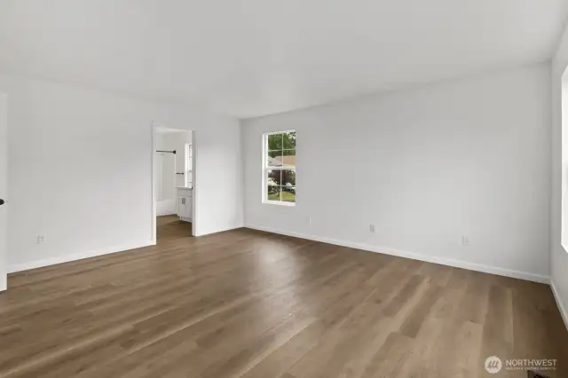 Another view of the spacious primary bedroom, leading into the attached bath.