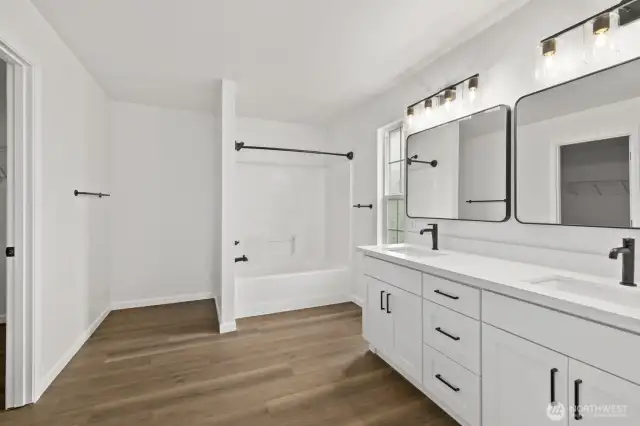 Welcome to the primary bath! This deceptively spacious room features a brand-new double vanity, along with new fixtures, lighting, and mirrors.
