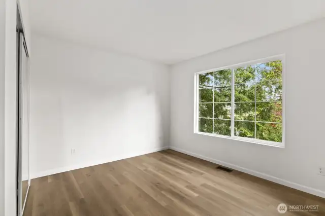 The last secondary bedroom, featuring double mirrored closet doors.