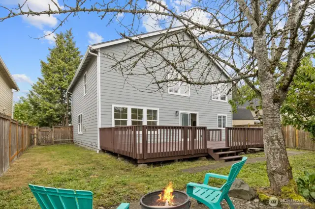 A view of the back of the home, showcasing the spacious deck and fully fenced yard!