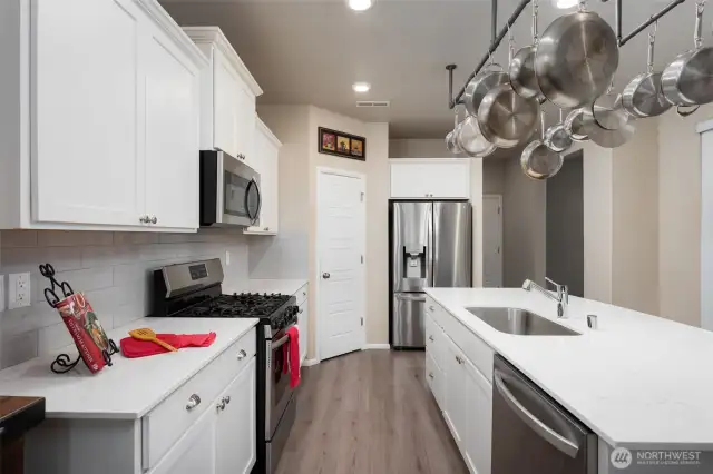 Chef's kitchen with panty, white cabinets and quartz counter tops.