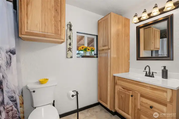 This home’s single bathroom is spacious, inviting, and beautifully decorated with a cozy, modern charm.