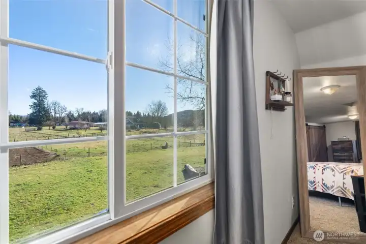 Primary bedroom overlooks the outdoor arena and pastures.