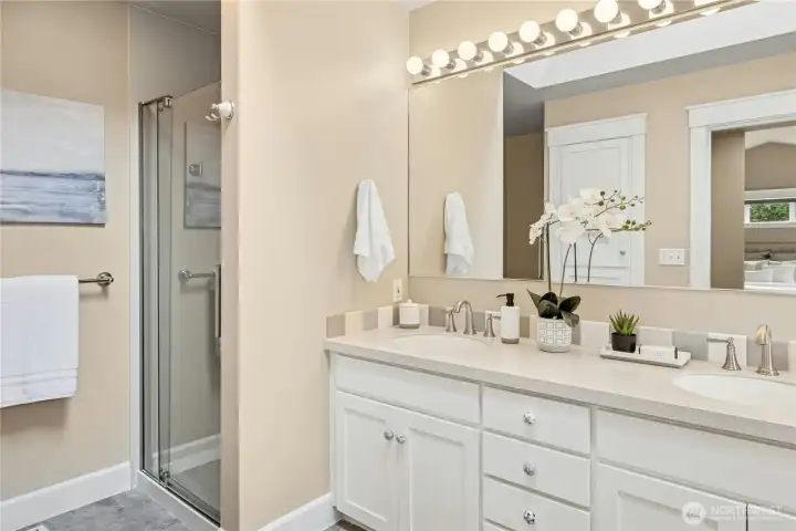 The refreshed primary bathroom with dual sinks, an updated shower, and soaking tub.