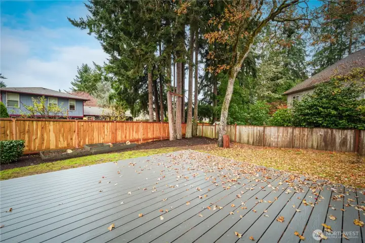 The fully fenced yard offers ample space for play or gardening, including raised garden beds.