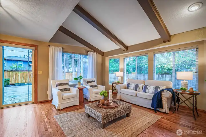 Back inside, note the abundant windows and gleaming hardwoods in this beautiful family room.