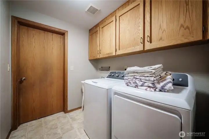 The main-floor utility room includes convenient cabinetry and access to the 2-car garage.