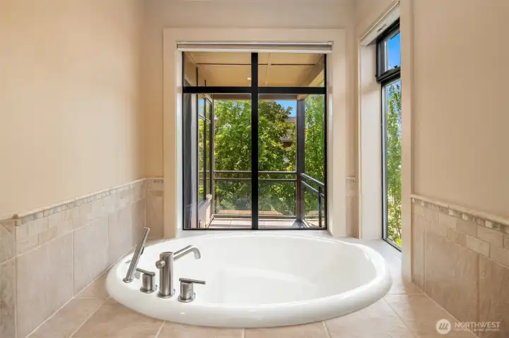 Soaking tub looks out towards the balcony.