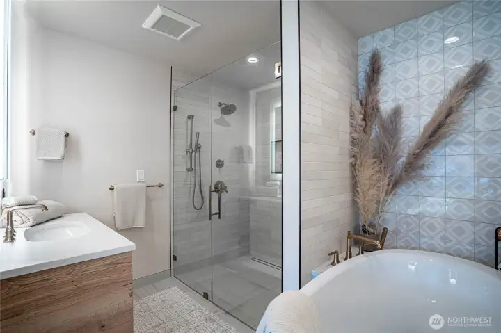 Oversized shower with massage fixtures and beautiful tile work.
