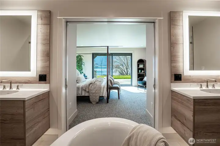 Twin bathroom sinks in the en suite primary bathroom with halo-illuminated mirrors.