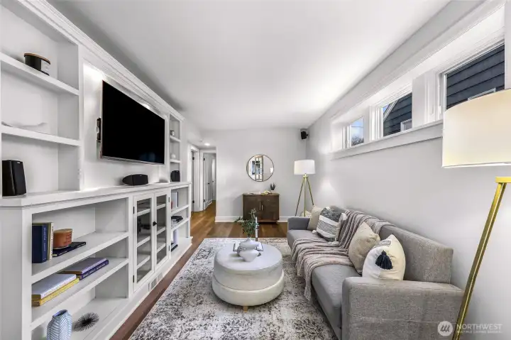 Media/family room in basement with built in, TV and speakers which stay.