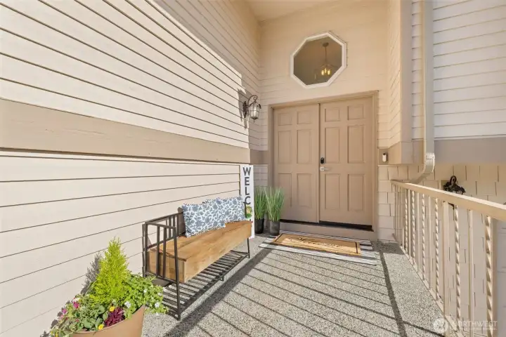 Grand double doors welcome you into a spacious entry porche, ideal for holiday décor and hanging plants, creating a warm, inviting feel