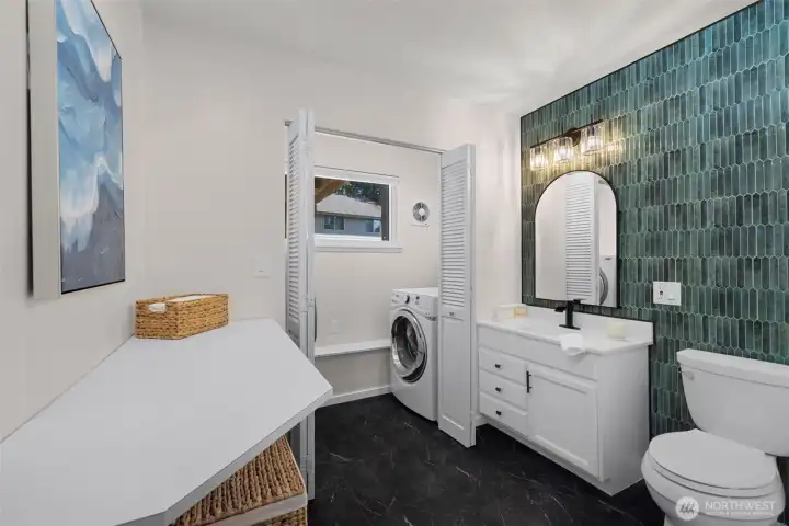 Stylishly updated lower-level 3/4 bath featuring a modern, chic, minimalist design, conveniently connected to the laundry room