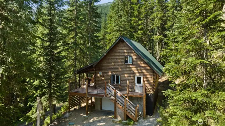 Another view of the front of this adorable cabin. Lower floor offers a garage and a great area for drying clothes and belongings that might get wet in the winter months.