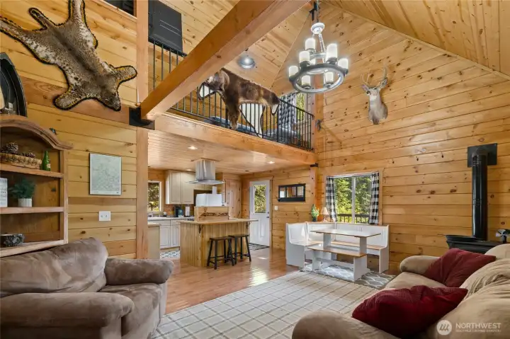 View of living room and dining area with a great open concept through out the cabin. Check out the beautiful pine and tongue and groove ceilings. Did I mention this cabin comes furnished?