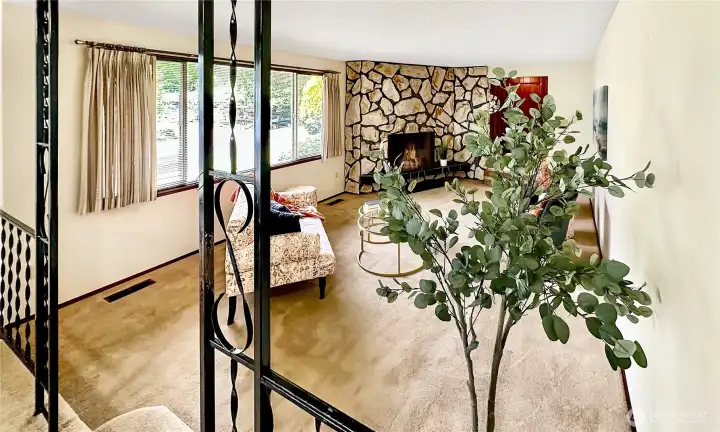 View from the dining room into the living room showing the wrought iron railing.