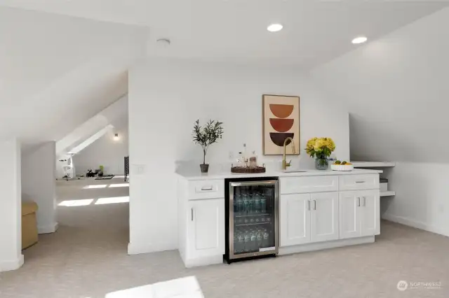 Opposite of sofa and TV you will find a wet bar with beverage refridgerator.
