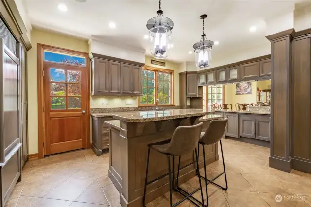 Large kitchen area with island seating and counter seating. Access to the back deck. Custom cabinets with pullouts.