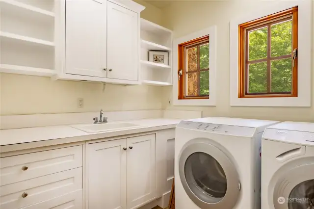 Utility room on the main level with sink and nice cabinet space
