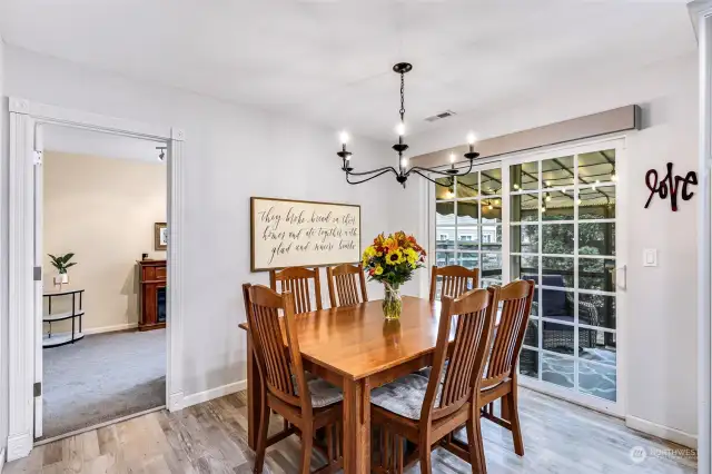 Spacious 2nd eating area with sliders leading to outdoor screened patio room and fenced yard.