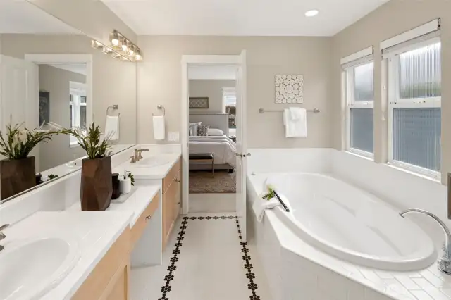 This spacious primary bath features a walk-in shower, private water closet, and generous counter space with two sinks—perfect for streamlined mornings.