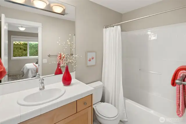 This full bathroom is ensuite to the second upstairs bedroom, offering convenience and privacy with a clean, timeless design and a tub/shower combo.