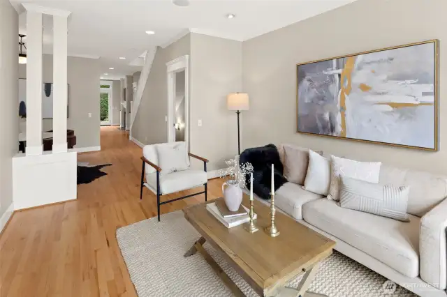 The inviting entry opens into a sun-filled living space with oversized windows, warm hardwood floors, and classic millwork that set the tone for the rest of the home.