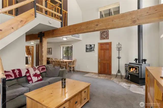 Come inside & cozy up! Soaring vaulted ceilings, pretty wood beams, & warm wood burning fireplace make this the perfect cabin in the woods.
